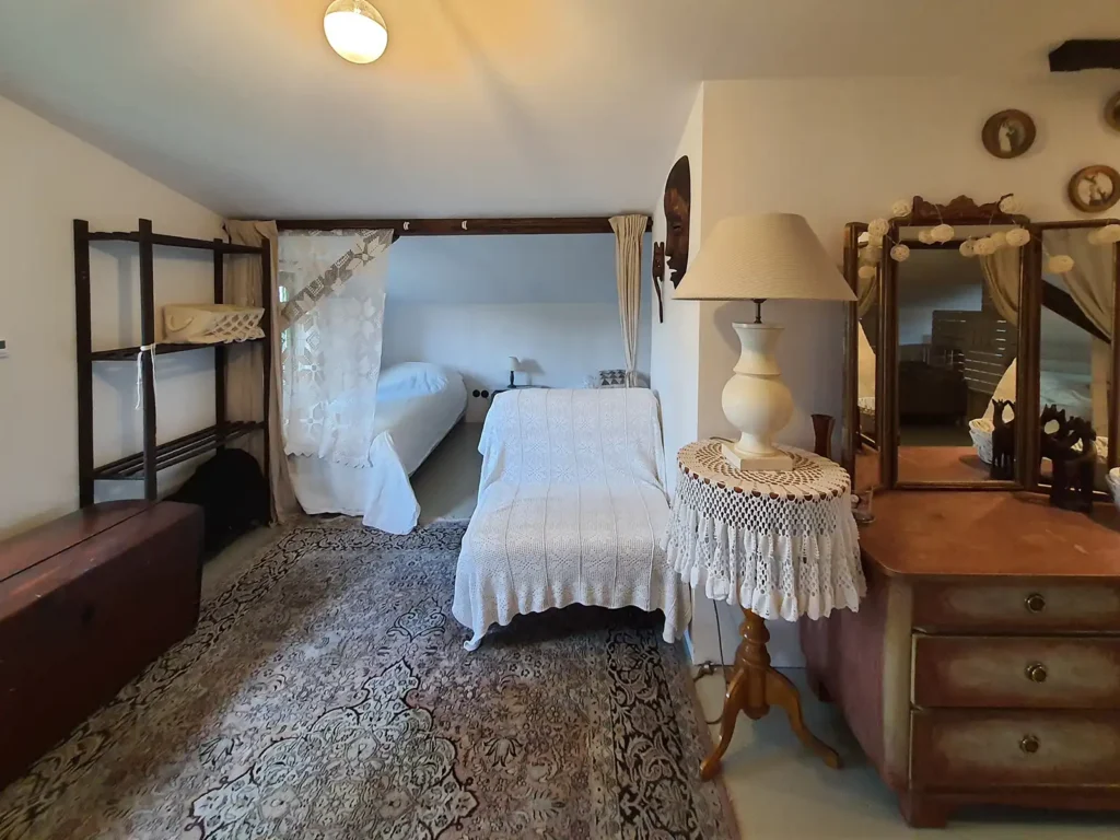 Poddasze Alkowa. Przytulna alkowa z łóżkami, oddzielona zasłonami, na Poddaszu Łuby Siedem. Wnętrze w stylu rustykalno-nowoczesnym, idealne na nocleg w Borach Tucholskich.